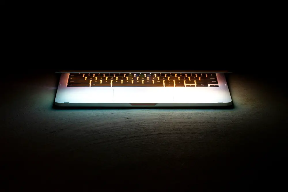 Notebook iluminado em um ambiente escuro