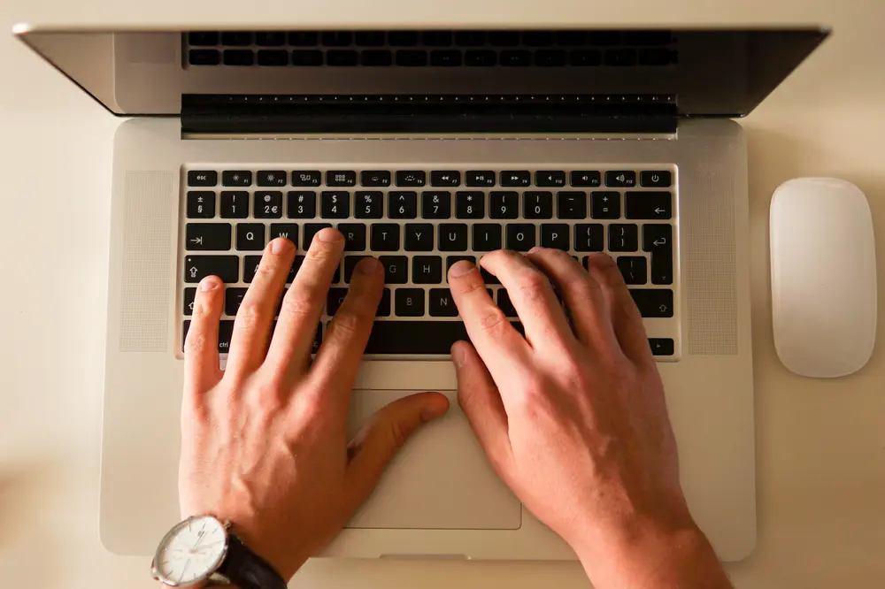 Mãos digitando em um notebook